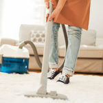 Frau macht sauber mit Teppichreiniger
