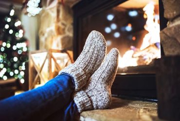 Frau mit Kuschelsocken am Kamin