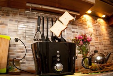 Toastbrot springt aus schwarzem Toaster