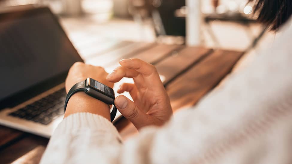 Frau schaut auf Smartwatch nach Bluthochdruck