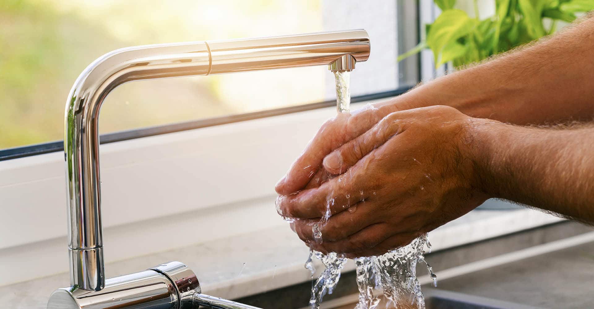 Mann wäscht sich Hände zur Hygiene über Spülbecken