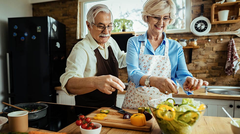Senioren-Paar bereitet cholesterinarme Nahrung zu