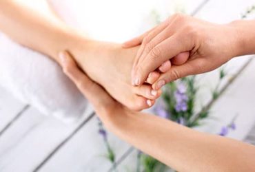 Frau kriegt am Fuß Behandlung gegen Nagelpilz