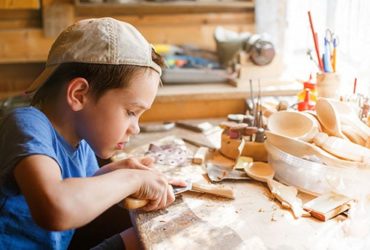 Junge arbeitet an Werkbank für Kinder