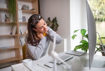Frau hat Nackenschmerzen im Home Office