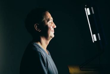 Mann nutzt Lichttherapie Lampe zuhause