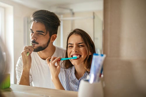 Paar putzt mit Zahnpasta Zähne