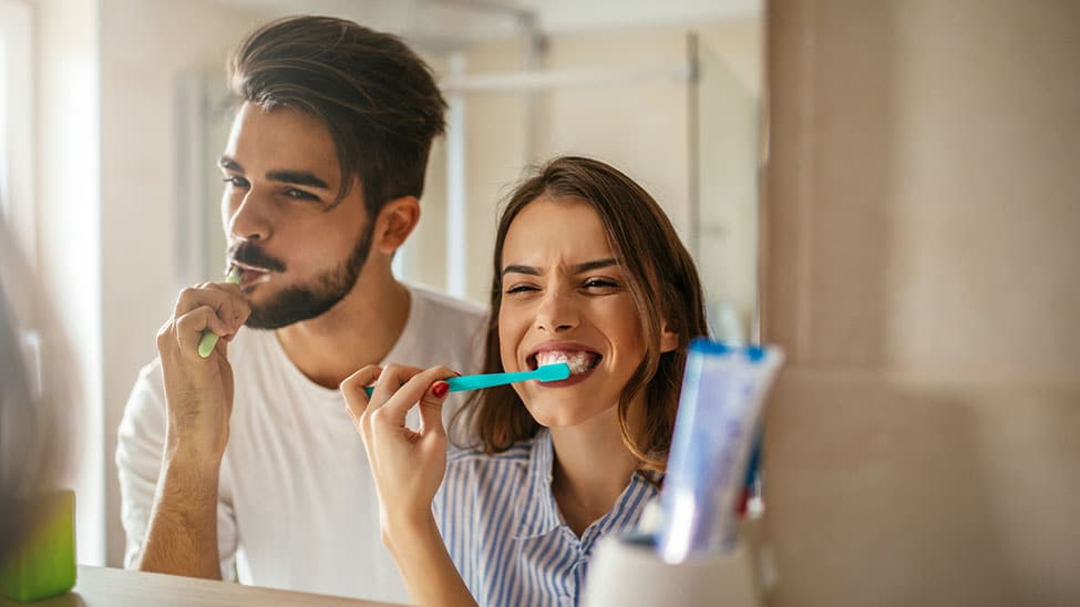 Paar putzt mit Zahnpasta Zähne