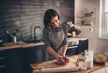 Frau backt Brot in Küche