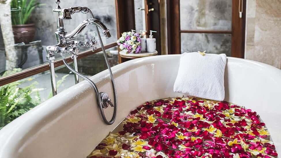 Badewanne mit Rosen drin und einem Badewannenkissen