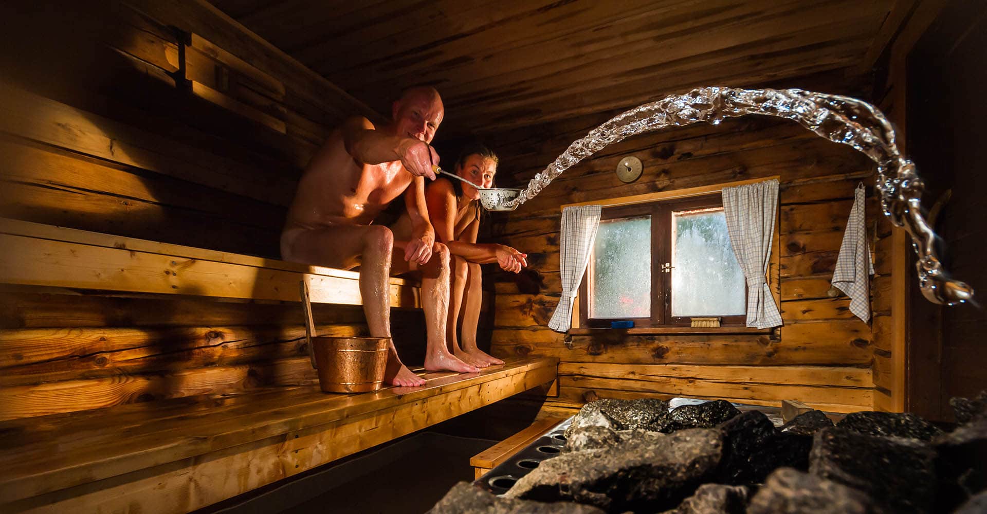 Paar in Garten Sauna macht Aufguss